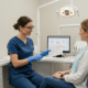 Dental hygienist explaining gum health to a patient in a modern clinic, showcasing affordable periodontist near me services.
