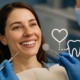 Smiling woman at dental checkup with a heart and tooth icon representing the link between oral health and heart disease.