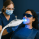 Dentist performing professional tooth whitening with blue LED light treatment in Los Angeles.